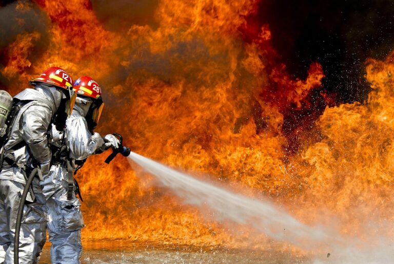Feuer löschen im Ernstfall – die besten Mittel und Vorgehensweisen Person benutzt Feuerlöscher richtig zum Feuer löschen in einer Haushaltssituation