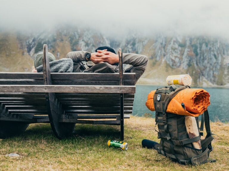 Person versorgt Verband an verletztem Knie im Outdoor-Notfall unter freiem Himmel